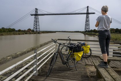 France, Charente Maritime, Rochefort, the Rochefort (or Martrou) transporter bridge built by Ferdinand Arnodin in 1900, cyclist along the cycle route