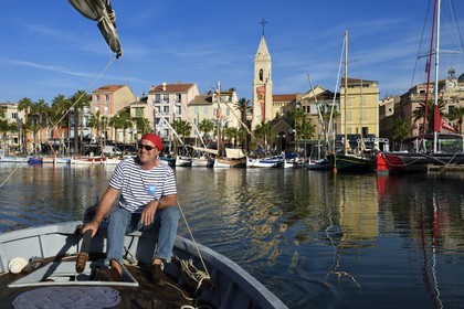 France, Var (83), Sanary-sur-Mer, barques traditionnelles de peche appelées pointus sur le port et l'église Saint-Nazaire, Christian Bénet qui est président de l'association des pointus de Sanary