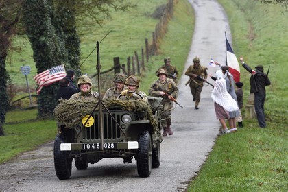 France, Eure (27), Sainte-Colombe-prés-Vernon, Allied Reconstitution Group (association de reconstitution historique de la 2éme Guerre Mondiale américain et Maquis), reconstitueurs en uniforme de la 101e division aéroportée US progressant en jeep Willys accueillis en libérateurs par des villageois et FFI