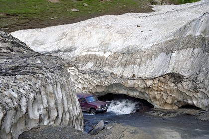 Géorgie, Kakheti, region de Touchétie, la très spectaculaire piste qui relie Telavi à Omalo au Col d'Abano (2826 mètres), voiture franchissant la rivière à gué à travers un névé