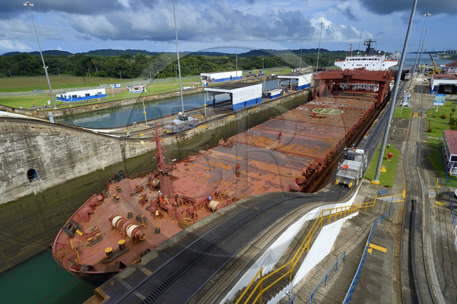 Panama, province de Colon, Canal de Panama, écluses de Gatun, mules mécaniques ou locomotives électriques guidant un cargo Panamax entre les murs de l'écluse