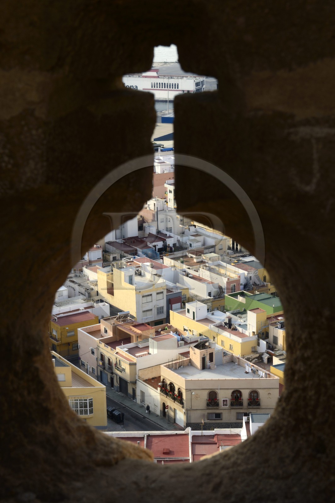 Spain, Andalusia, Almeria, view of the Medina neighborhood in the old city through a Alcazaba fortress loophole