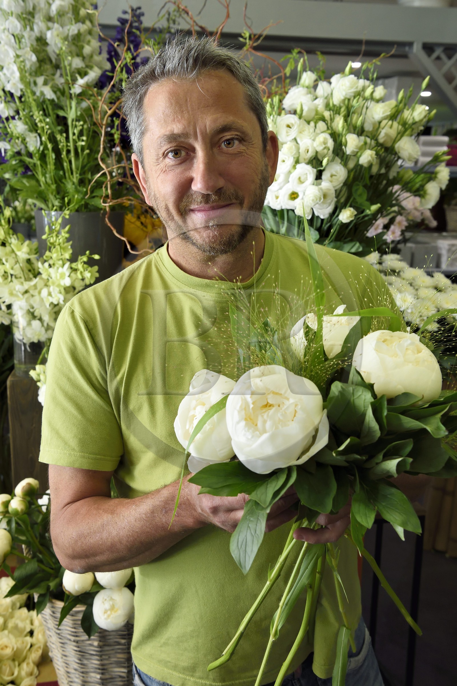 France, Alpes-Maritimes, Nice, Joseph Pinna the florist holding a white peony in his shop Arc en ciel flowers rue Barberis