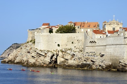 Croatie, Dalmatie, cote dalmate, Dubrovnik, centre historique classé Patrimoine Mondial de l'UNESCO, kayaks passant au pied des remparts coté mer et l'église Saint Ignatius (Saint Ignace) en arrière plan