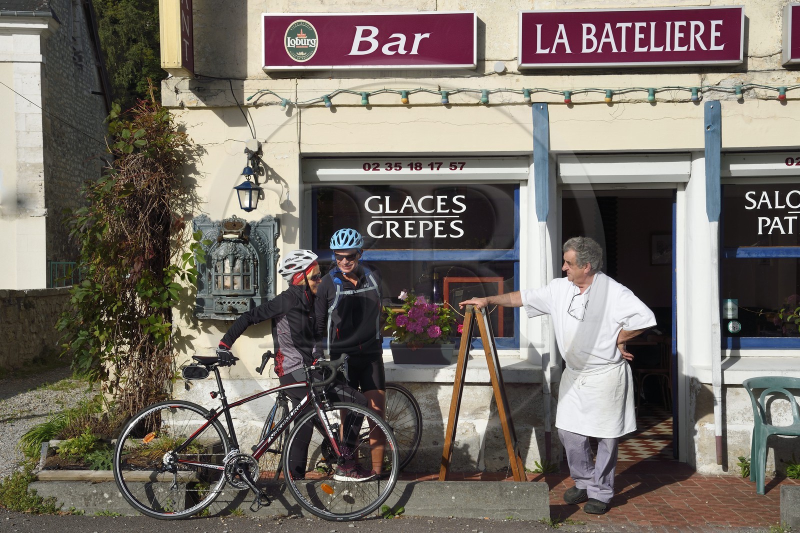 France, Eure, the village of Bas-Caumont in the norman Seine river meanders, cyclists passing the Bar and Restaurant La Bateliere from Brigitte et Raymond Godebout on the Veloroute of Val de Seine