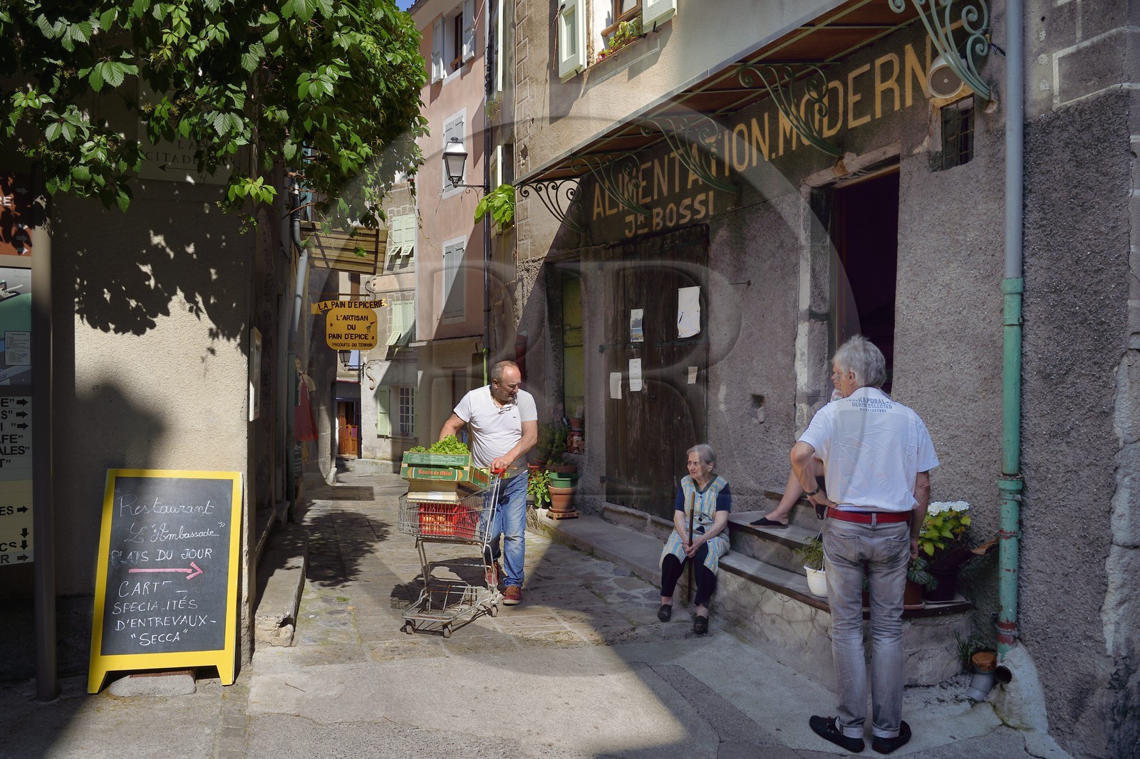 France, Alpes-de-Haute-Provence (04), cité médiévale d'Entrevaux fortifiée par Vauban, discussion devant l'épicerie de la vieille ville rue de la Porte Royale