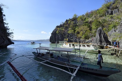 Philippines, Calamian Islands dans le nord de Palawan, Coron Island Natural Biotic Area, pirogue à balancier au pied des rochers de calcaire dans une petite crique