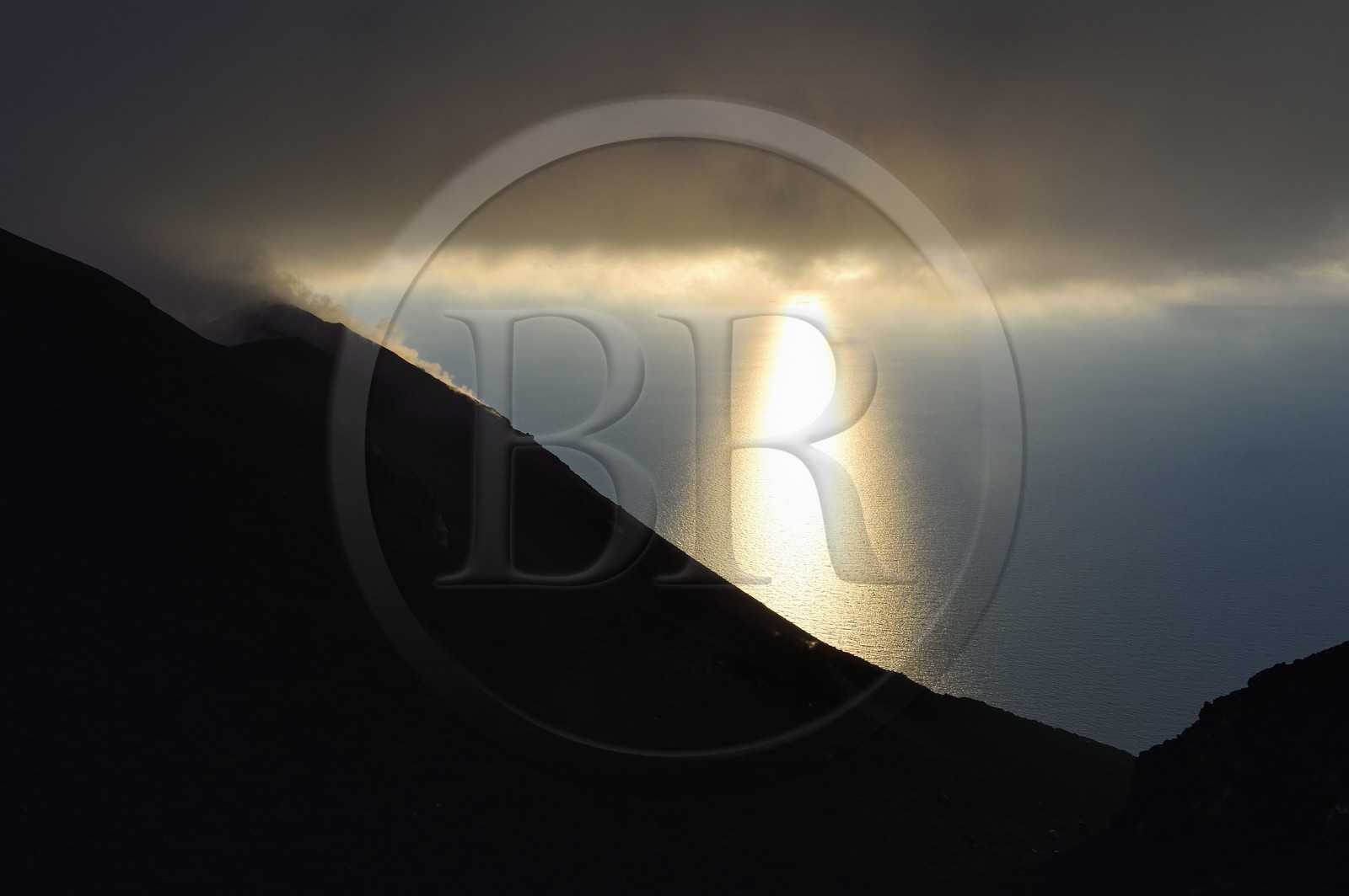 Italy, Sicily, Aeolian Islands, listed as World Heritage by UNESCO, Stromboli island, fumaroles and clouds on the slopes of the active volcano at sunset
