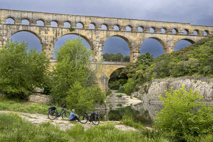 France, Gard (30), le Pont du Gard classé Patrimoine Mondial de l'UNESCO, Grand Site de France, cycliste prenant une pause devant le pont aqueduc romain qui enjambe le Gardon