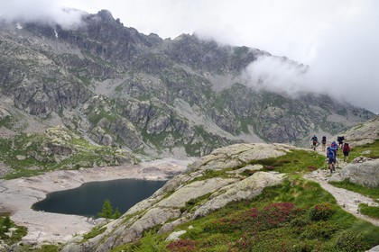 France, Alpes-Maritimes (06), parc national du Mercantour, vallée de la Valmasque, randonneurs sur le sentier de randonnée au dessus du lac Vert
