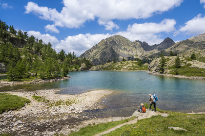 France, Alpes-Maritimes, Parc National du Mercantour (Mercantour national park), Haute Vesubie, Saint Martin Vesubie, Val du Haut Boréon, hikers at the Trecolpas lake (2150m) and the Cime Guilié (2999m) in the background