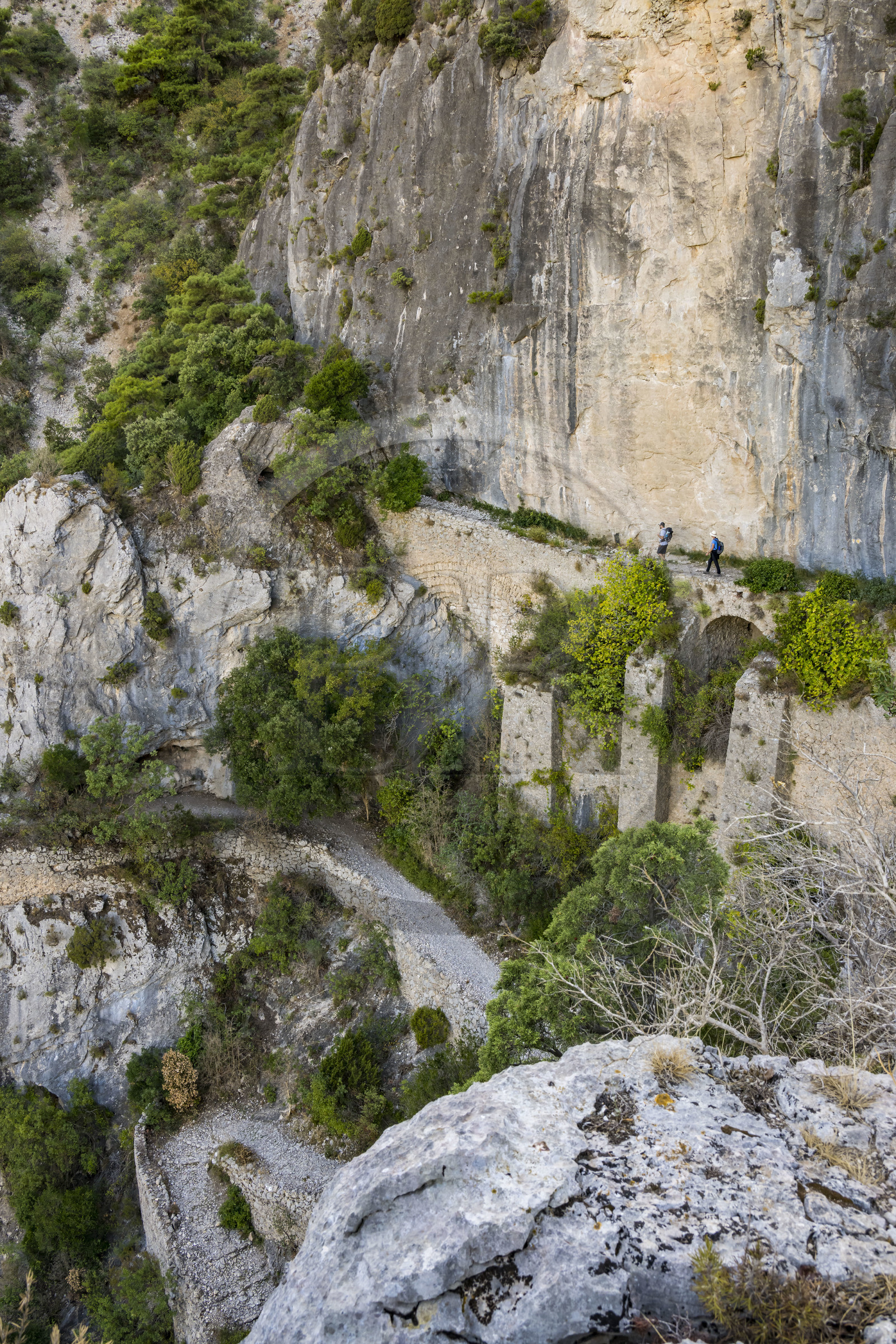 France, Hérault (34), Causses et les Cévennes, paysage culturel de l'agro-pastoralisme méditerranéen, classés Patrimoine Mondial de l'UNESCO, Saint-Guilhem-le-Désert, labellisé Les Plus Beaux Villages de France, randonneurs sur la Via Tolosana sur le Chemin de Saint-Jacques-de-Compostelle, le passage des Fenestrelles aménagé au Moyen-age par les moines de l'abbaye afin de franchir ce verrou rocheux dans le cirque de l'Infernet