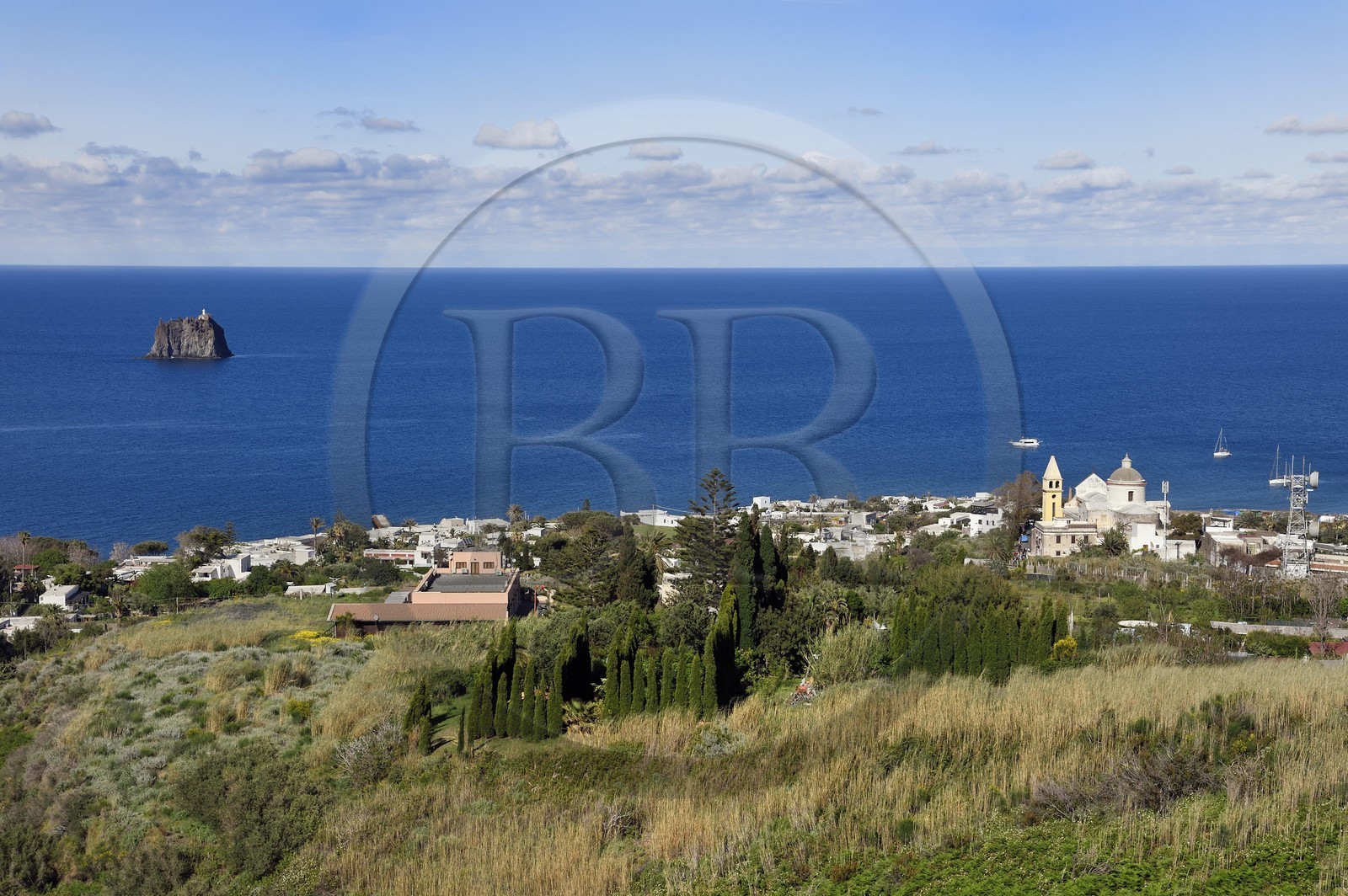 Italy, Sicily, Aeolian Islands, listed as World Heritage by UNESCO, Stromboli island, the village of Stromboli and the islet of Strombolicchio, rock of solidified magma from an old volcanic cap, in the background
