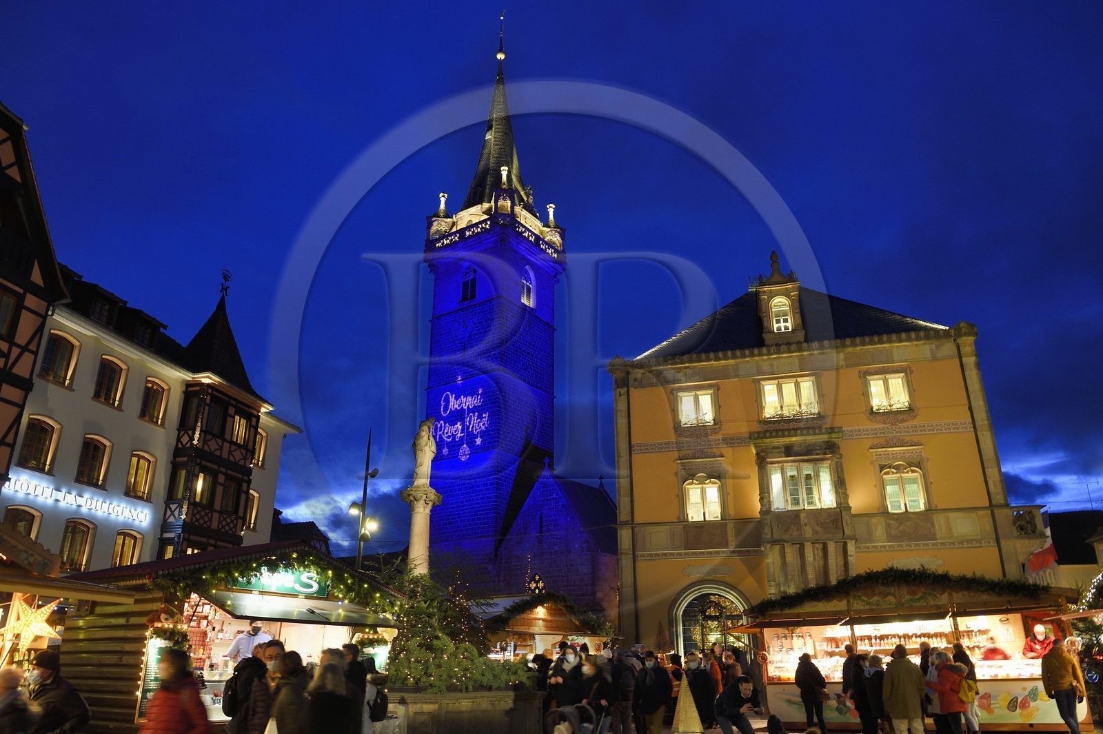 France, Bas Rhin, Obernai, Christmas market on the market square, Chapel Tower (Kappelturm) completed in the 16th century, serves as a belfry next to the town hall