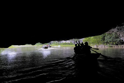 Vietnam, province de Ninh Binh, région surnommée la baie d'Halong terrestre, excursion en barque à Tam Coc entouré de paysages karstiques, passage d'une des trois grottes naturelles crées par la rivière