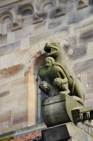 France, Bas-Rhin (67), Rosheim, église romane Saint-Pierre et St-Paul, sculpture en bosses rondes, l'acrotère luxurieux symbolise le péché, un homme richement vêtu apparait écrasée par un lion menacant