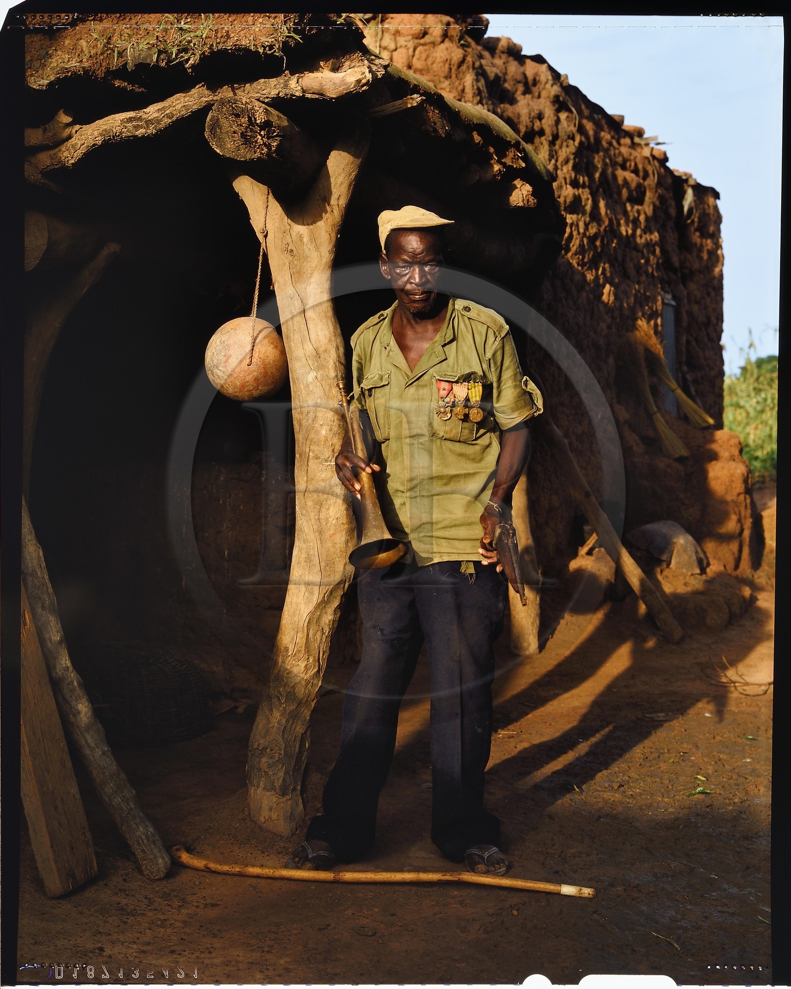 Burkina Faso, province de Poni, pays des Lobi, Loropéni, l'ancien combattant français médaillé qui a, dixit, fait l'Indochine, l'Algérie et Paris 18ème posant avec un pistolet de fabrication artisanal dans sa cour de ferme