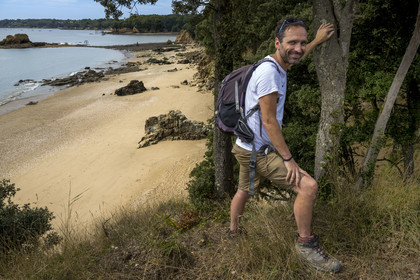 France, Loire Atlantique, Estuaire de la Loire, Saint Nazaire, Kerloupiots beach, hiker Stéphane Le Naour on the customs officers' path at the start of the GR 34 long-distance trail