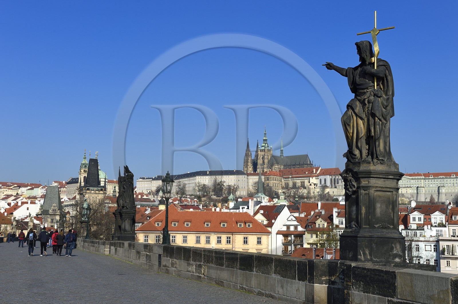 Czech Republic, Prague, historical centre listed as World Heritage by UNESCO, statue of John the Baptist on Charles Bridge (Karluv Most) and St. Vitus cathedral overlooking the Royal Castle in the background
