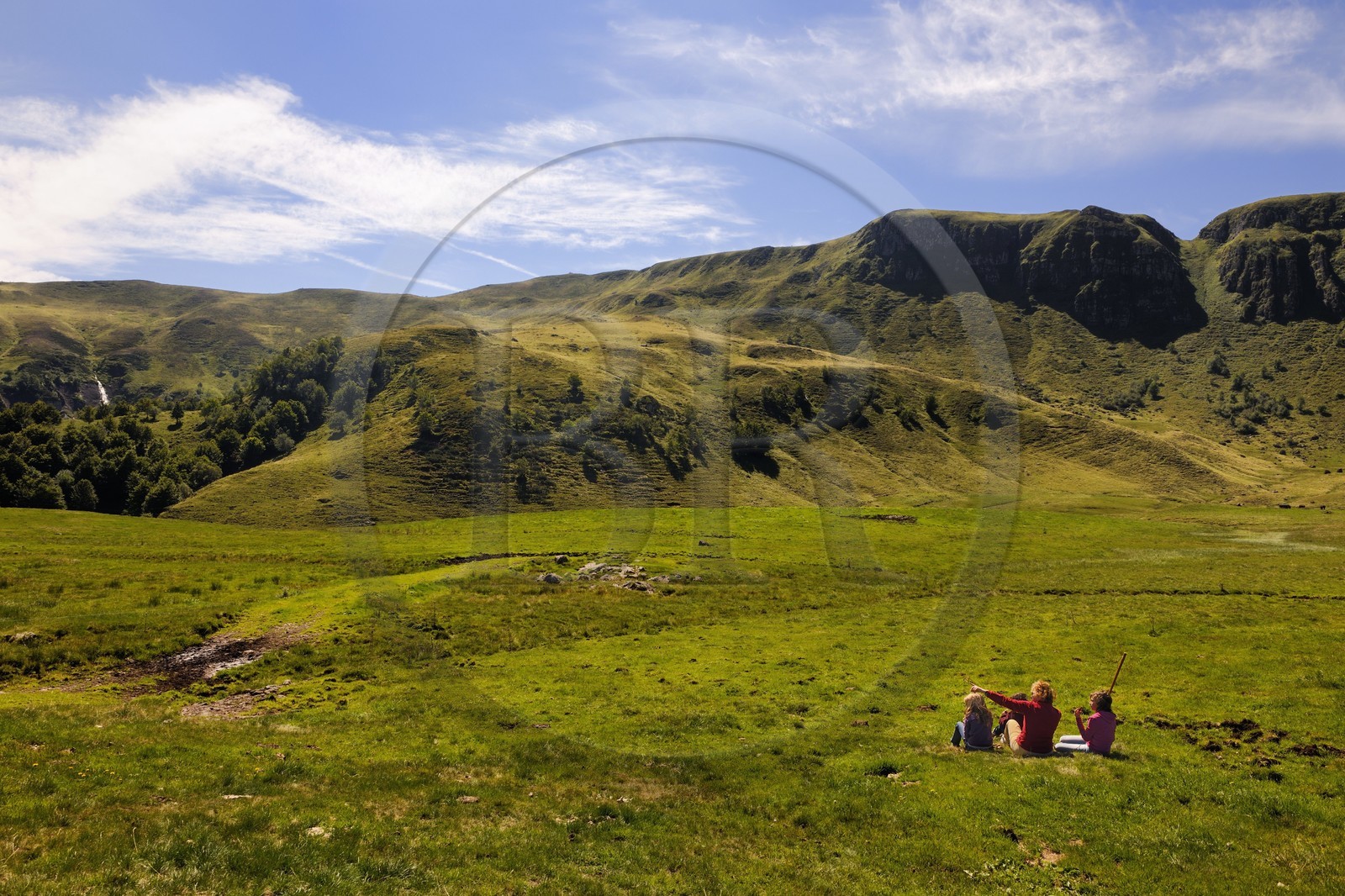 France, Cantal, France, Cantal, monts du Cantal, Parc Naturel Régional des Volcans d'Auvergne (regional nature park of Auvergne volcanoes), Puy-Mary, family of hikers at the foot of the mountain of the Fours de Peyre Arse cut by the breach of Roland