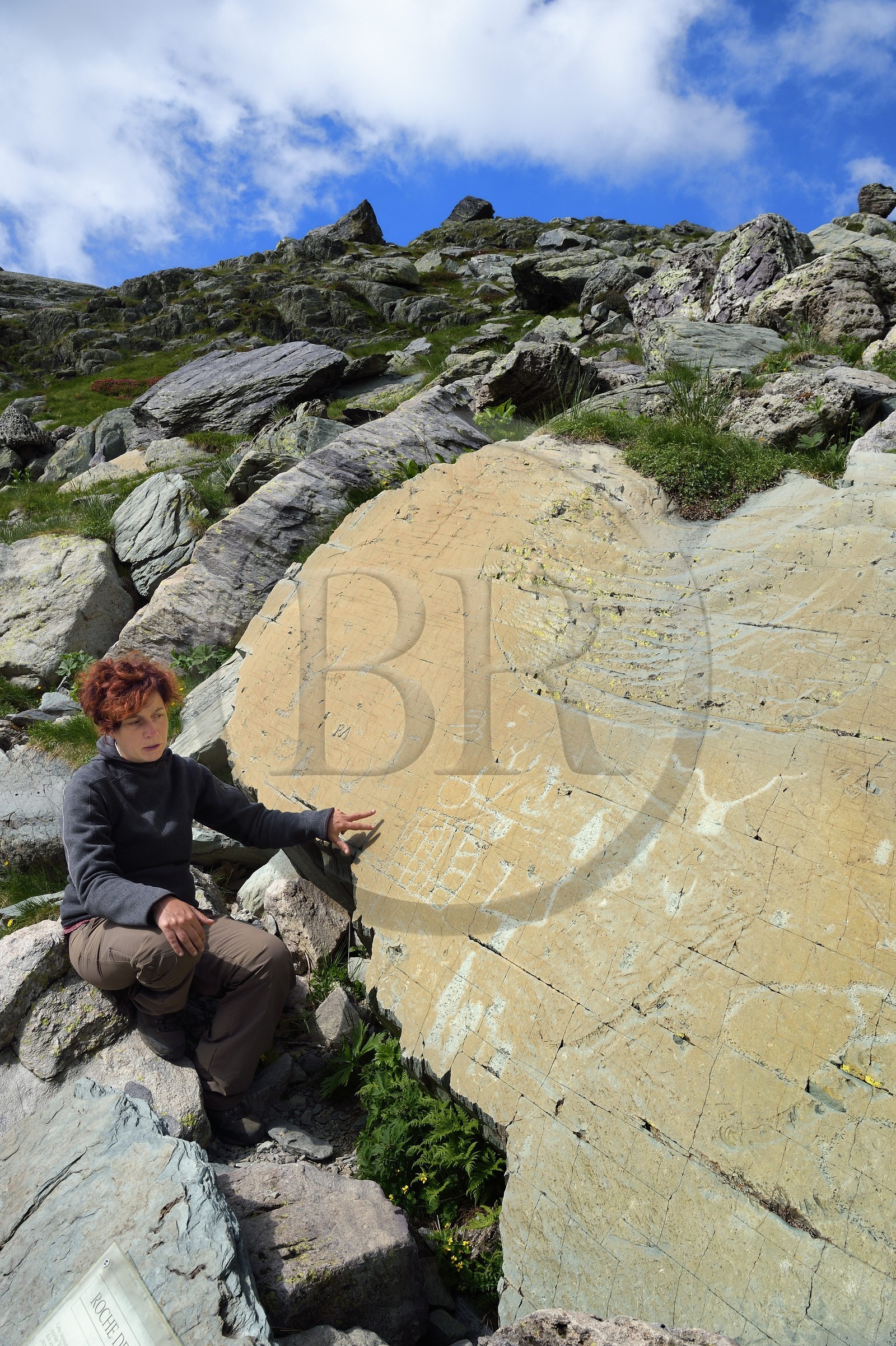 France, Alpes-Maritimes (06), parc national du Mercantour, Vallée des Merveilles parsemée de milliers de gravures rupestres de l'Age de bronze, l'archéologue Nicoletta Bianchi étudie la Roche de l’Eclat gravée de figures corniformes, de poignards et d'un grand réticulé qui symboliserait les champs cultivés