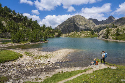 France, Alpes-Maritimes, Parc National du Mercantour (Mercantour national park), Haute Vesubie, Saint Martin Vesubie, Val du Haut Boréon, hikers at the Trecolpas lake (2150m) and the Cime Guilié (2999m) in the background