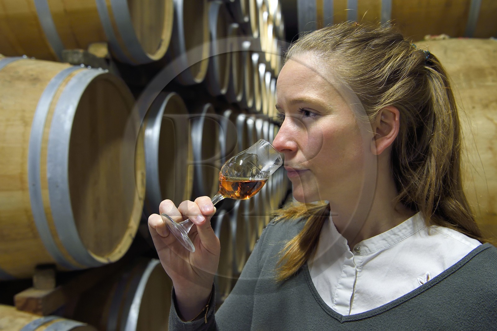 France, Charente (16), Sireuil, Distillerie des Moisans, dans les chais de vieillissement et d'assemblages, la responsable du développement des activités commerciales Laurette Didière sent le cognac