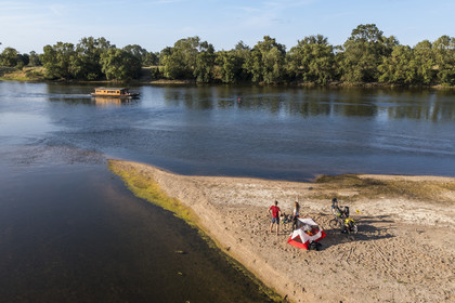 France, Maine-et-Loire (49), vallée de la Loire classée au Patrimoine Mondial par l'UNESCO, randonnée à bicyclette le long des berges de la Loire, campement pour la nuit sur un des bancs de sable formant des îles sur la Loire, une gabarre (bateau traditionnel à fond plat) en arrière plan (vue aérienne)