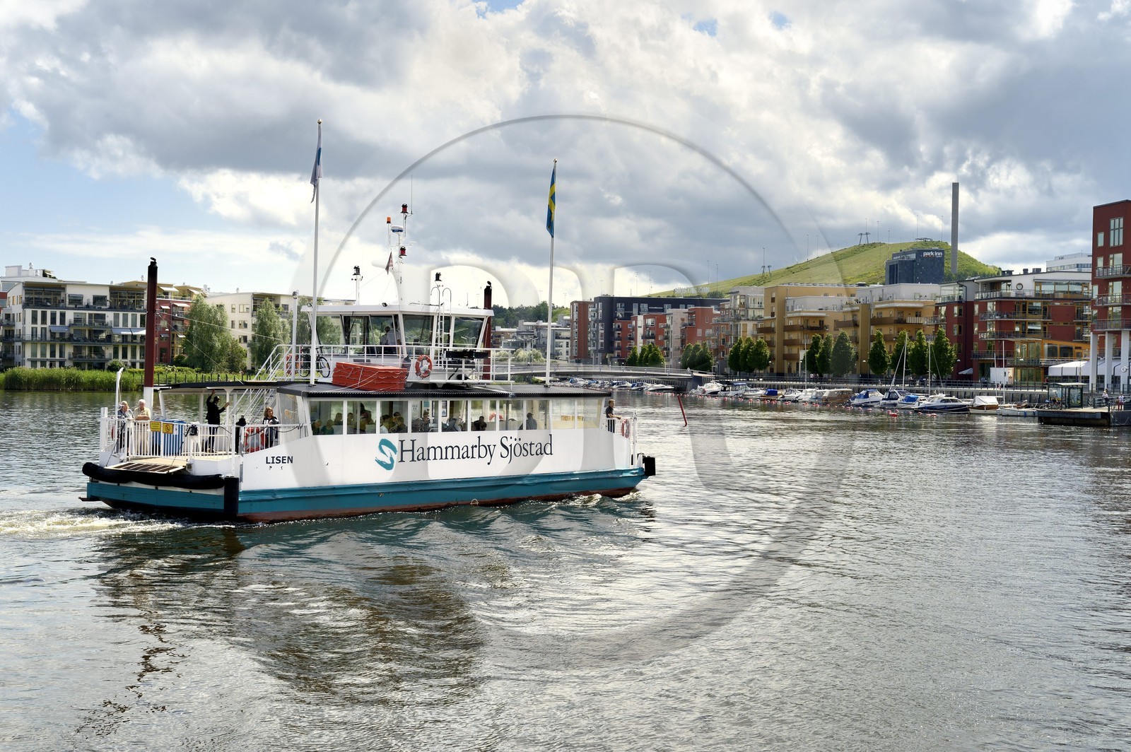Suède, Stockholm, l'écoquartier Hammarby Sjostad précurseur en matière de développement durable, ferry sur le lac Hammarby et la piste de ski (en hiver) de Hammarbybacken en arrière plan