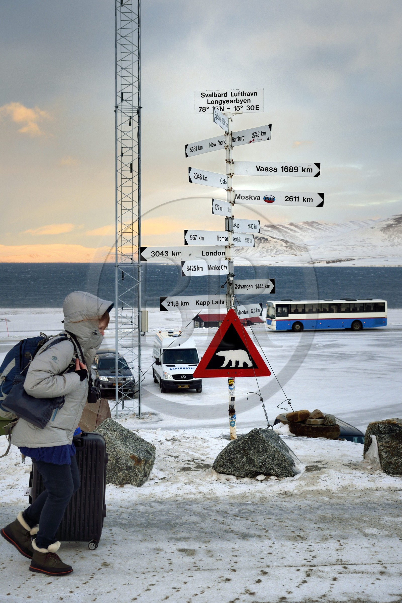 Norway, Svalbard, Spitzbergen, Longyearbyen, direction and distance signs in front of Longyearbyen Airport and warning sign of potential danger of presence of polar bear