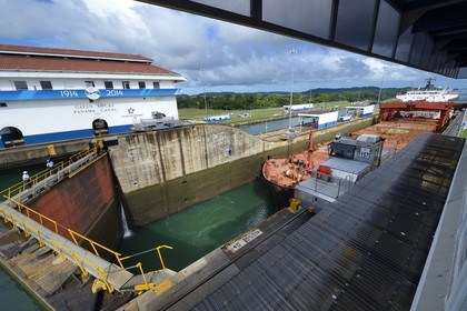 Panama, province de Colon, Canal de Panama, écluses de Gatun, mules mécaniques ou locomotives électriques guidant un cargo Panamax entre les murs de l'écluse