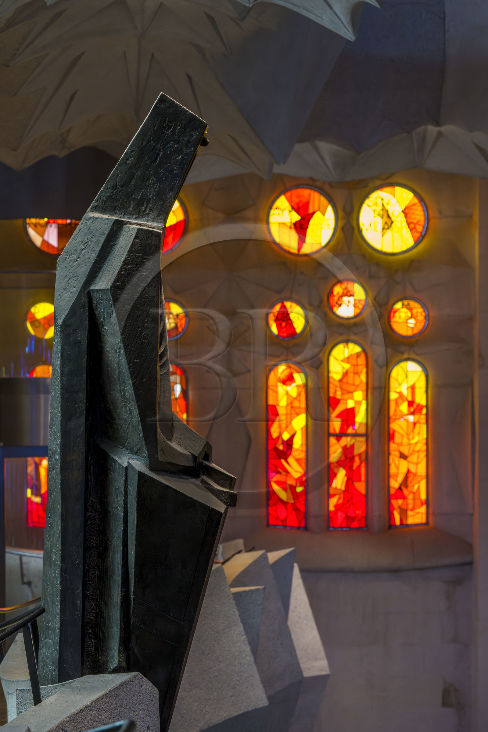 Spain, Catalonia, Barcelona, Eixample district, Sagrada Familia basilica by Catalan modernist architect Antoni Gaudi, listed as a UNESCO World Heritage Site, bronze statue of Saint George (Sant Jordi) by the sculptor Subirachs in the center of the interior of the Glory facade and the facade side of the Passion of the Nave with its warm-colored stained glass windows