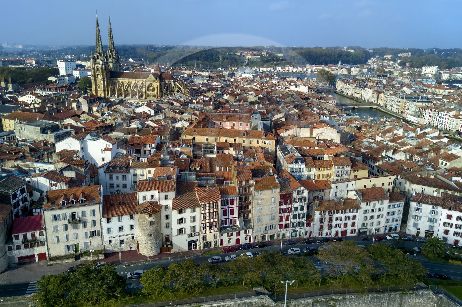 France, Pyrénées-Atlantiques (64), Pays-Basque, Bayonne, les flèches de la cathédrale Sainte-Catherine derrière les tours des anciens remparts intégrées dans les immeubles de la rue Tour de Sault, la Nive à droite et l'Adour en arrière plan (vue aérienne)