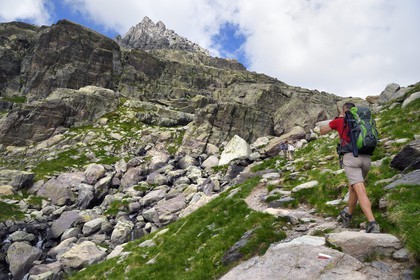 France, Alpes-Maritimes (06), parc national du Mercantour, Vallée des Merveilles parsemée de milliers de gravures rupestres de l'Age de bronze, randonneurs sur le sentier de randonnée GR 52 passant sous le Mont des Merveilles (2720m)