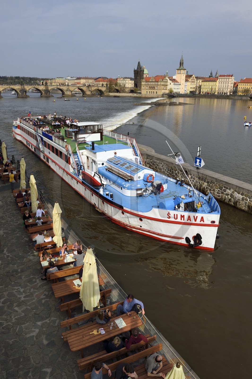Czech Republic, Prague, Kampa district, riverboat in front of the Kampa Museum, Charles Bridge over the Vltava River in the background