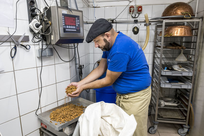 France, Vaucluse, Saint Didier, In the Nougats Silvain workshop,  nougat makers peasant, Charles-Henri Bagnol makes a slab of black nougat, weighing the roasted almonds