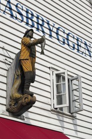 Norvège, Hordaland, Bergen, statue de pêcheur sur la facade d'une maison en bois