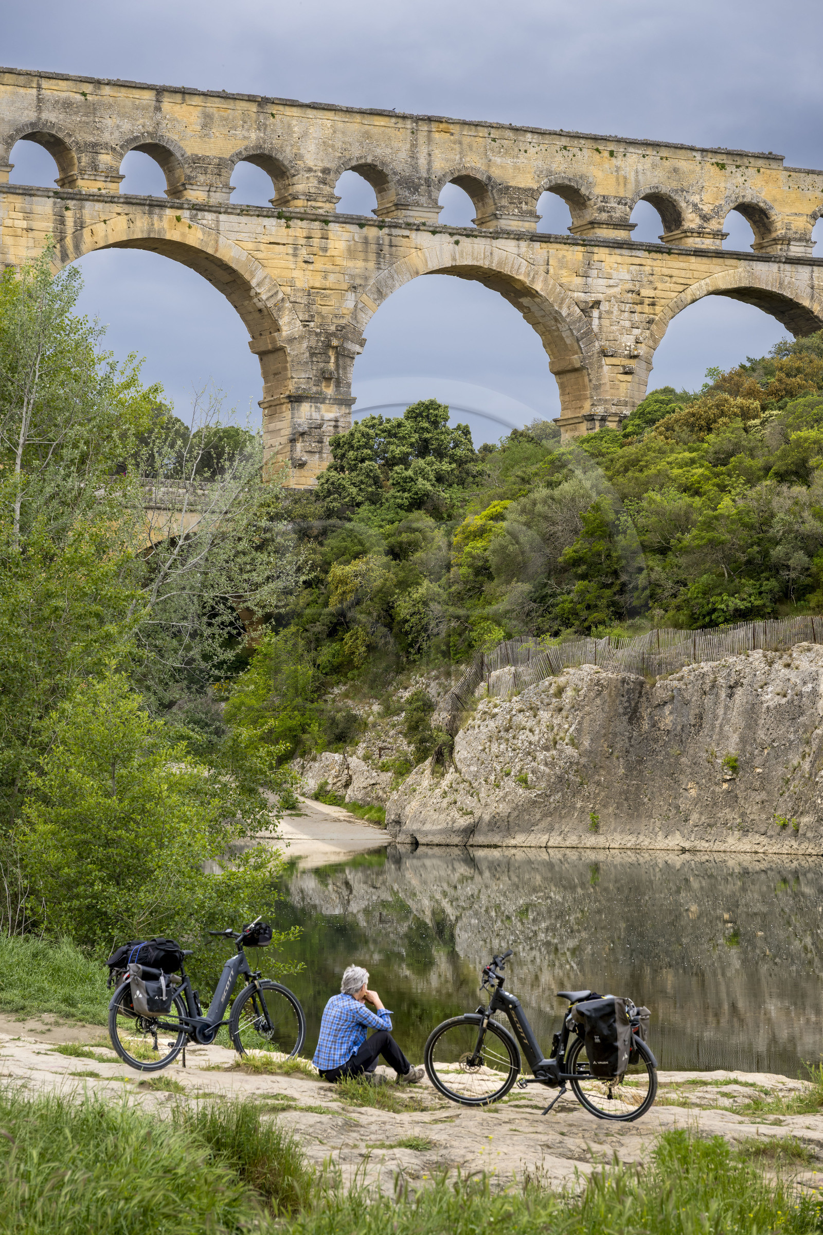 France, Gard (30), le Pont du Gard classé Patrimoine Mondial de l'UNESCO, Grand Site de France, cycliste prenant une pause devant le pont aqueduc romain qui enjambe le Gardon