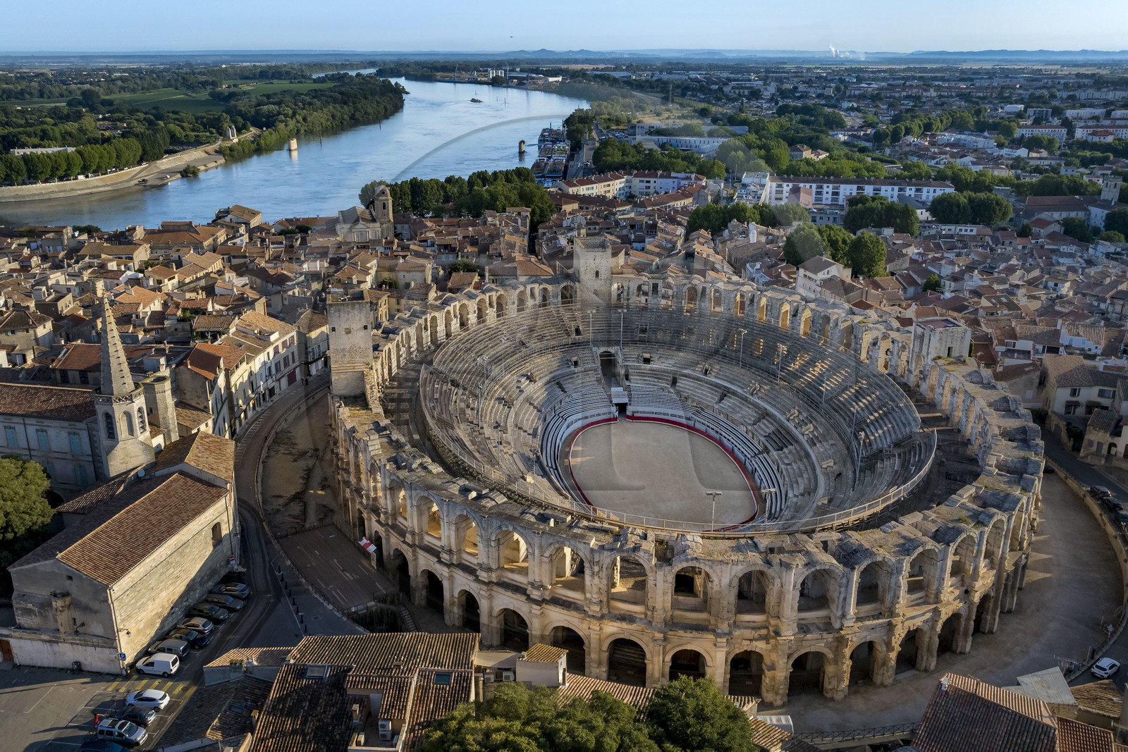 France, Bouches-du-Rhône (13), Arles, les Arènes, amphithéatre romain construit vers 80-90 apr. J.-C., classé Patrimoine Mondial de l'UNESCO, au coeur de la vieille ville, l'église du couvent des Cordeliers à gauche et le Rhone en arrière plan (vue aérienne)