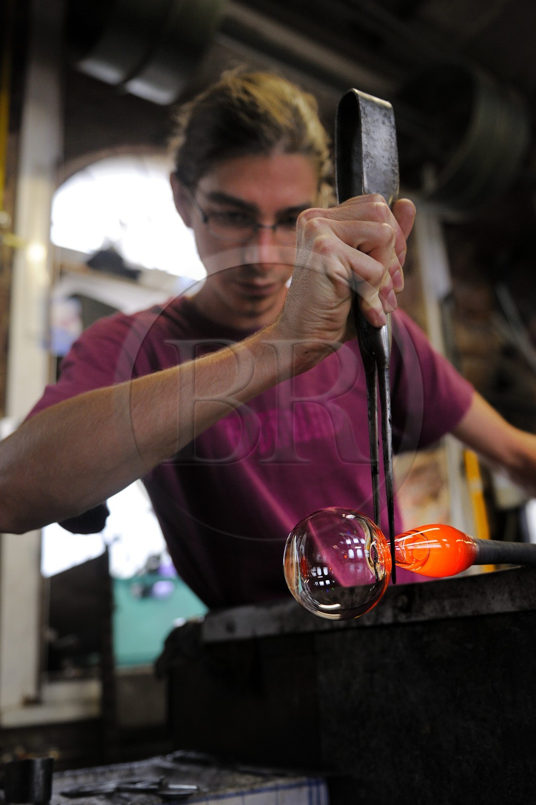 France, Moselle, Meisenthal, souffleur au Centre international d'Art verrier (CIAV), making of a christmas bowl made of glass, blowpipe put on a bench called «gamin mecanique», Thibault using his trade's cutters