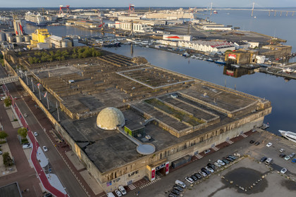 France, Loire-Atlantique (44), Saint-Nazaire, les anciennes bases sous-marines allemandes construites lors de la dernière guerre mondiale bordent le bassin à flot du port de Saint-Nazaire, en arrière plan à gauche le bassin de Penhoët et à droite le pont de Saint-Nazaire (vue aérienne)