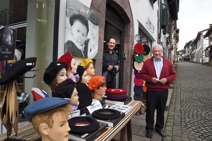 France, Pyrénées-Atlantiques (64), Pays-Basque, Saint-Jean-Pied-de-Port, rue d'Espagne sur le chemin de Saint-Jacques-de-Compostelle, l'ancien champion de pelote grand chistera Michel Cavier et son père Jean Cavier à droite devant leur boutique de vêtements