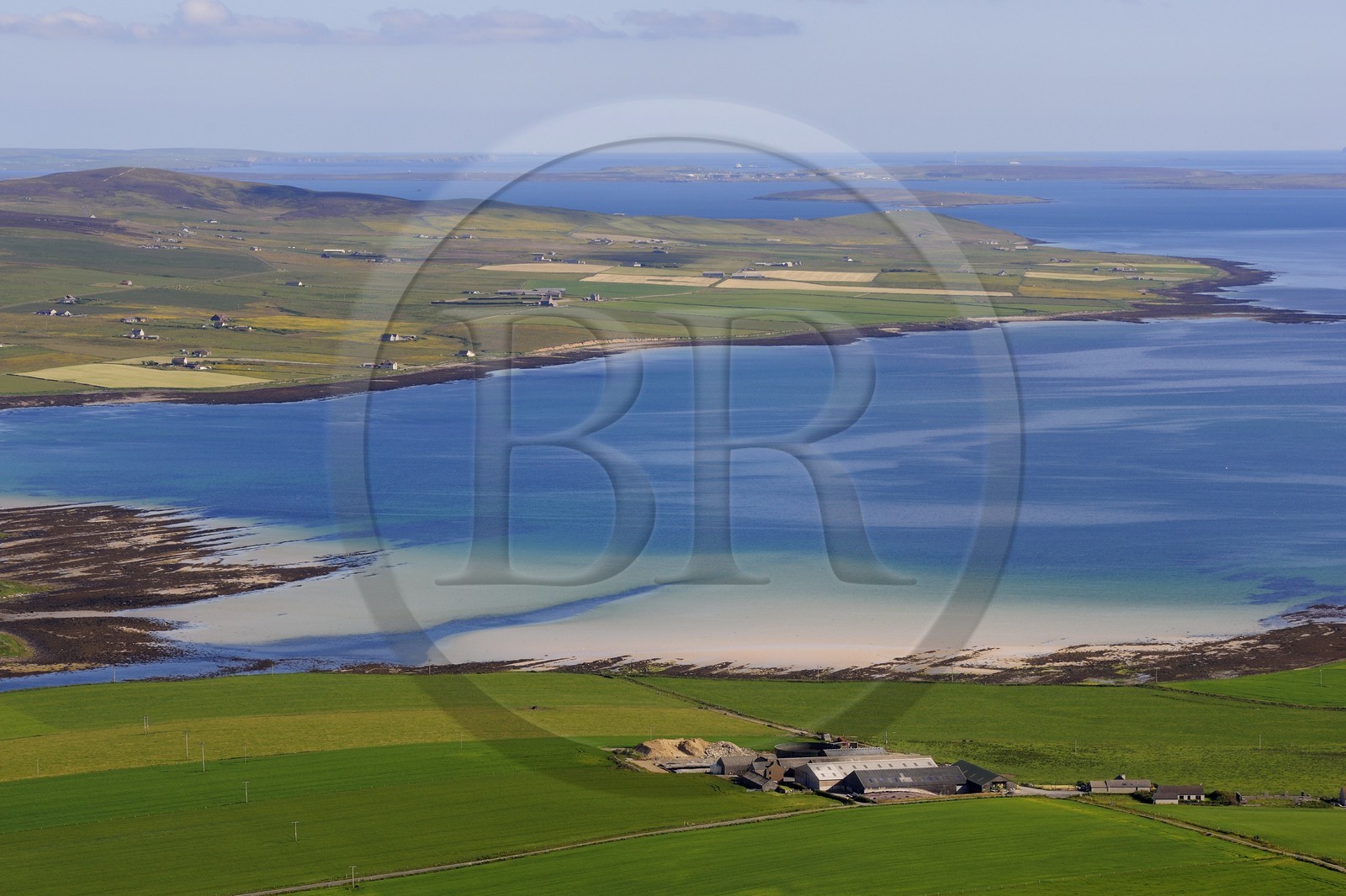 United Kingdom, Scotland, Orkney Islands, Mainland Island, fields and farms by the sea and island of Flotta in the background (aerial view)
