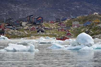 Greenland, west coast, Disko Bay, Ilulissat, Zion Church built in the late 18th century and icebergs in the foreground, social housing in the background