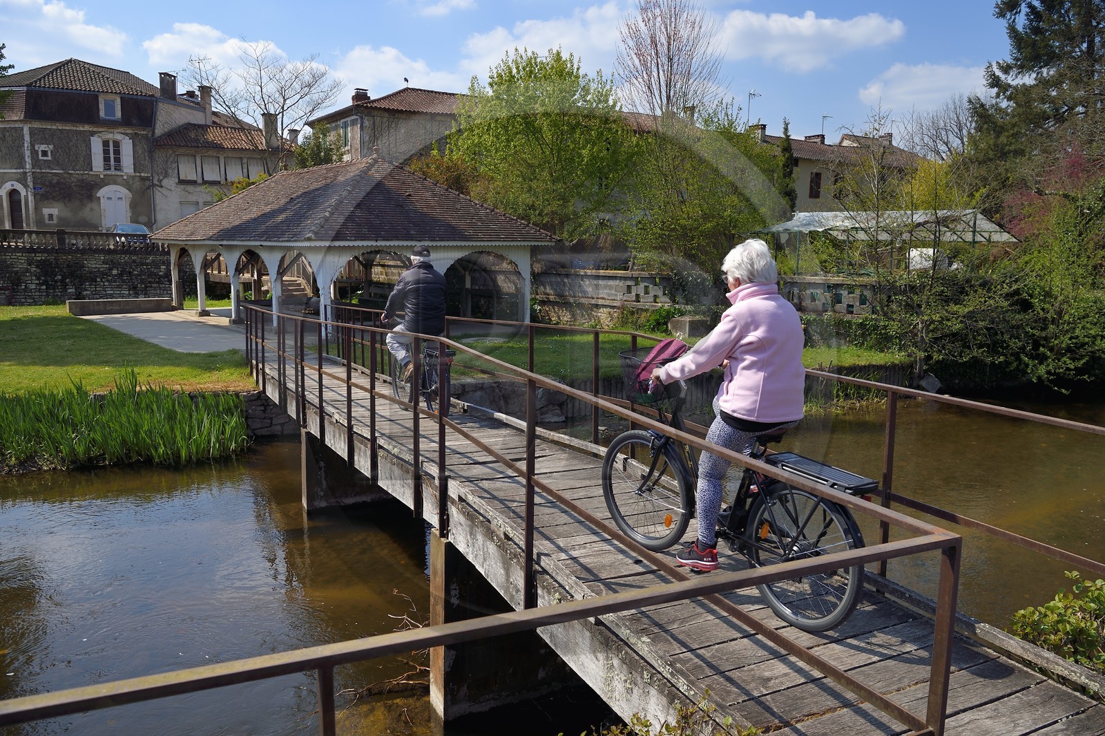 France, Dordogne (24), Saint-Pardoux-la-Rivière, cyclistes traversant le petit pont sur la Dronne pour rejoindre le vieux lavoir en arrière plan