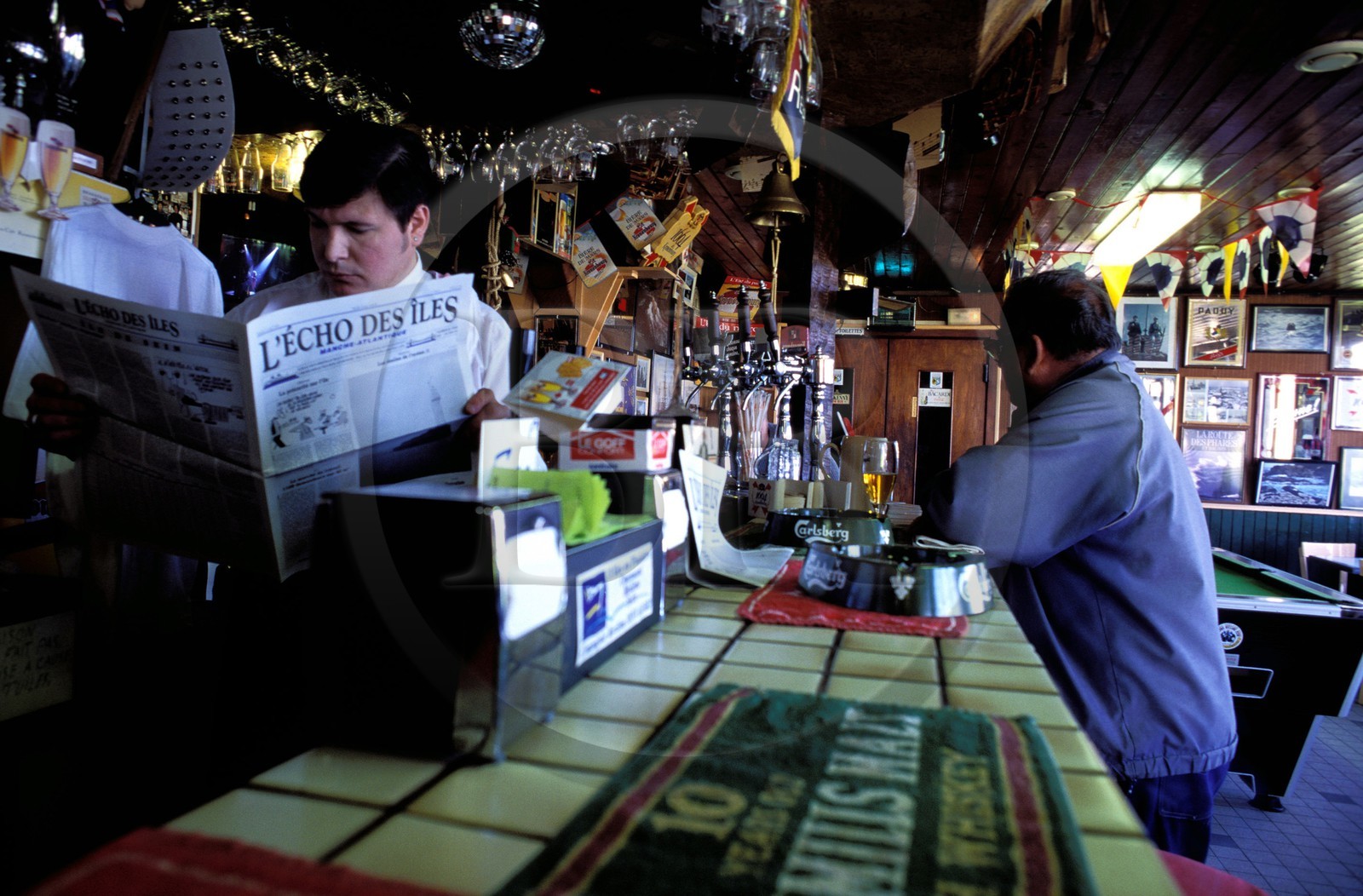 France, Finistère (29), île de Molène, le patron du seul Café de l' île lisant le journal l' écho des îles
