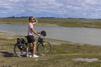 France, Vendée (85), île de Noirmoutier, Barbatre, cycliste sur l'estran en bordure du passage du Gois, chaussée submersible qui relie l'île au continent à marrée basse