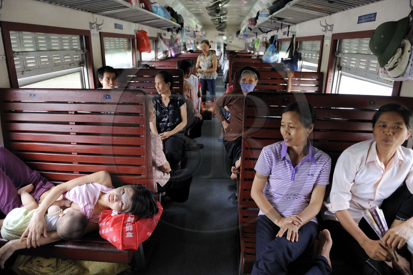 Vietnam, train de jour de Lao Cai à Hanoï, classe assis dur non climatisé, une maman allaite son enfant