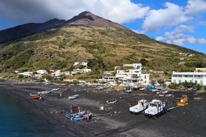 Italie, Sicile, iles Eoliennes, classées Patrimoine Mondial de l'UNESCO, ile de Stromboli, pecheurs sur la plage de Scari et le volcan actif du Stromboli en arrière plan (vue aérienne)