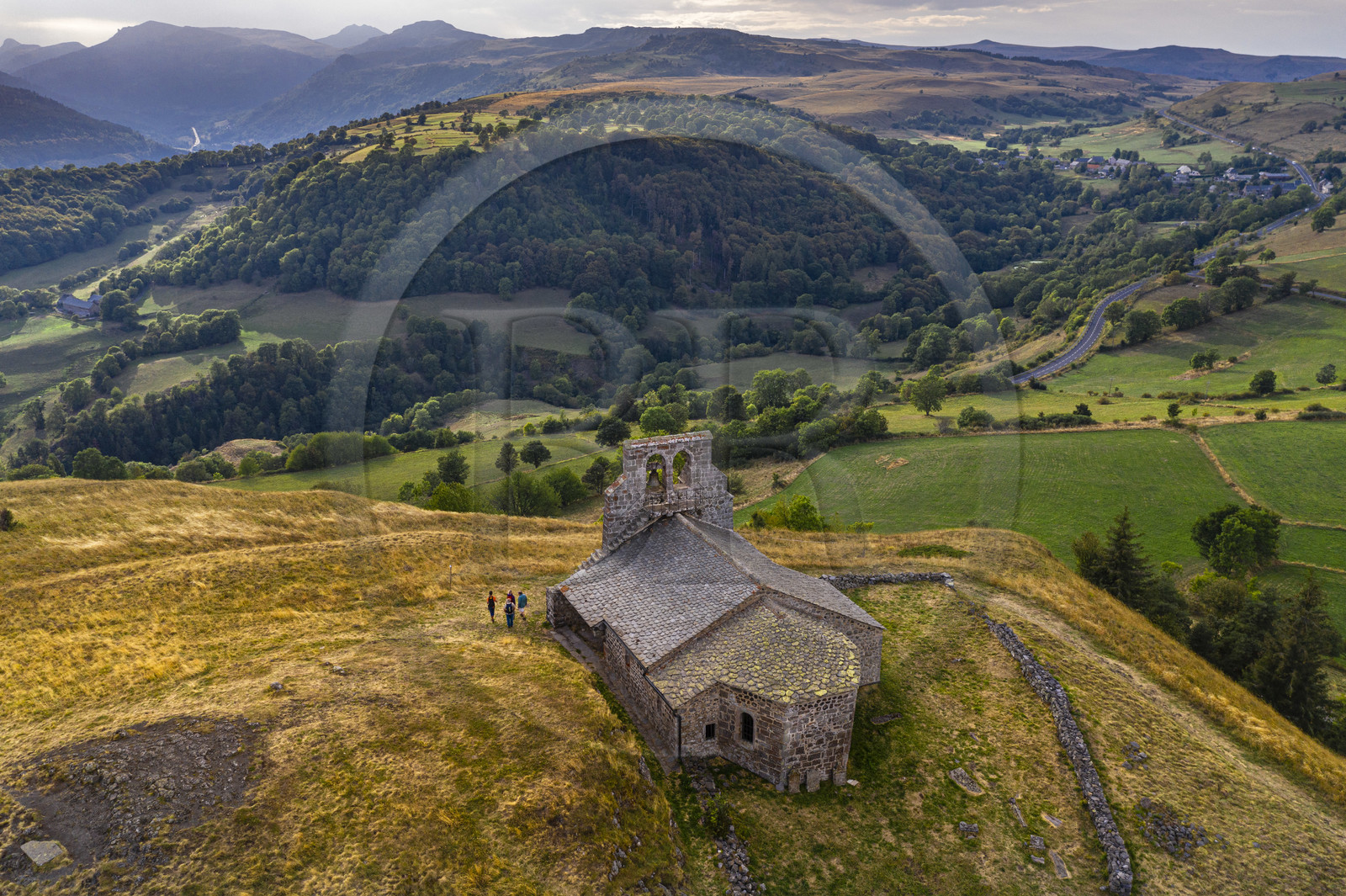 France, Cantal, Parc Naturel Régional des Volcans d'Auvergne (regional nature park of Auvergne volcanoes), Chastel-sur-Murat, 12th century perched on a promontory Saint Antoine (Saint Anthony) Chapel, hickers on the Way of St. James to Santiago de Compostela by Via Arverna (aerial view)